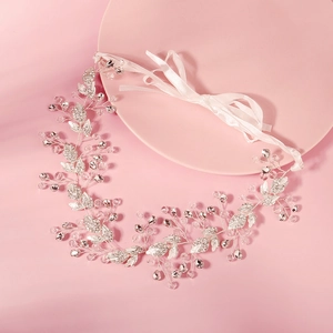Détail du bandeau de mariée avec feuilles de cristal, strass et ruban de soie rose