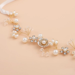 Détail d'un bandeau de mariée fait main avec fleurs dorées, perles et cristaux