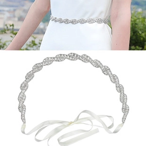 Dettaglio della cintura da sposa fatta a mano con strass scintillanti e nastro di seta bianca