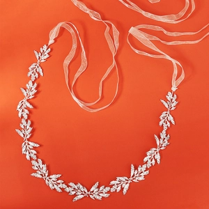 Silver bridal belt with leaf patterns and rhinestones on orange background
