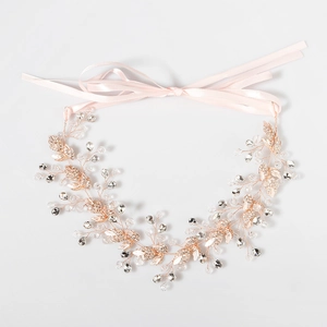 Détail d'une vigne de cheveux de mariée or rose avec feuilles cristal et perles blanches