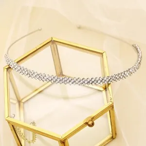 Detailed macro view of a thin silver double-row rhinestone headband on a glass display box