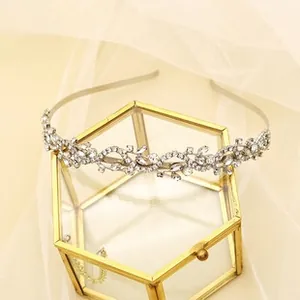Detail of silver rhinestone headband with vine leaves on a glass jewelry box