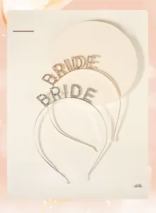 Detail of silver and gold rhinestone BRIDE headbands on a stone display tray