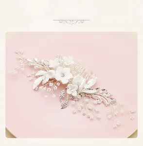 Detail of bridal hair comb with white ceramic flowers, pearls and crystals