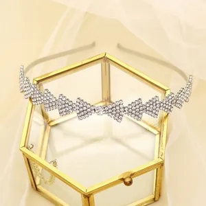 Detail of silver rhinestone headband with geometric triangular pattern on a glass box