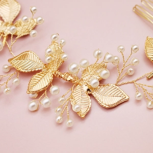 Détail macro du peigne à cheveux de mariée avec feuilles dorées et perles blanches