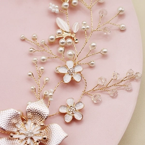 Détail d'un bandeau de mariée avec fleurs en émail blanc, perles et cristaux brillants