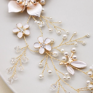 Détail d'un bandeau de mariée fait main avec perles, cristaux et fleurs dorées