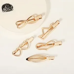 Détail d'un lot de 5 barrettes dorées aux motifs ajourés de couronnes et de cœurs