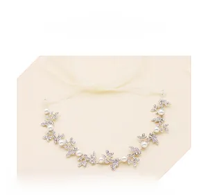 Dettaglio di foglie di vite in argento con strass e perle sulla fascia da sposa