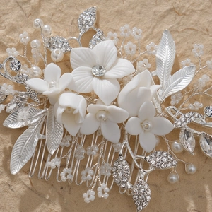 Elegant bridal hair comb featuring white ceramic flowers, pearls, and silver crystals