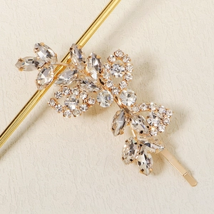 Barrette dorée élégante avec strass et motif de feuilles sur fond blanc pur