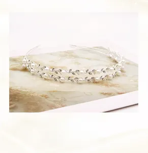 Détail d'un serre-tête de mariée fait main avec fil de cuivre perles et strass en feuilles