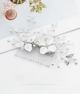 Détail du peigne de mariée avec fleurs vernies blanches, perles et feuilles de cristal