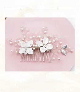 Détail du peigne de mariée avec fleurs blanches, cristaux et perles sur un plateau rose