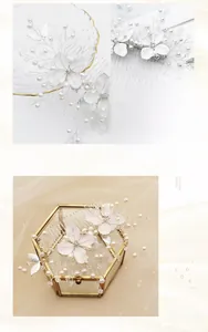 Détail d'un peigne à cheveux de mariée avec fleurs en métal blanc et perles nacrées