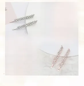 Detailed view of two silver hairpins set with sparkling rhinestones in a sleek design