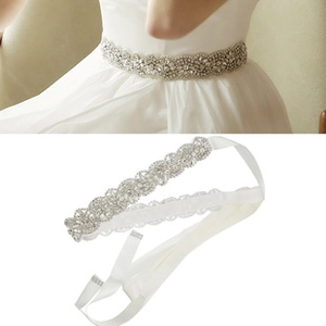 Detail of bridal sash with wavy rhinestone patterns and white satin ribbon ties