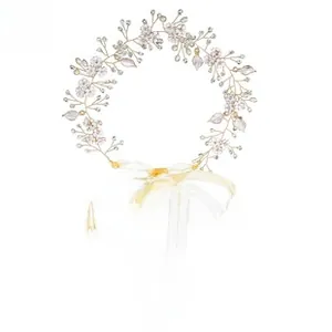 Close-up of golden bridal hair comb with white petals, pearls and yellow organza ribbons