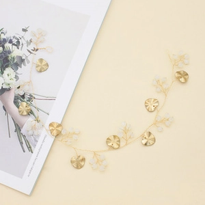 Detailed close-up of golden bridal hair vine with heart leaves and frosted beads