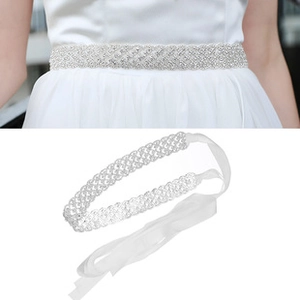 Detail of bridal dress sash featuring high-density rhinestones with white satin ribbons