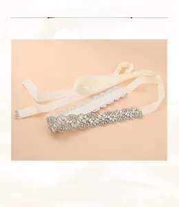 Detailed view of rhinestone bridal sash with leaf patterns on cream ribbon band