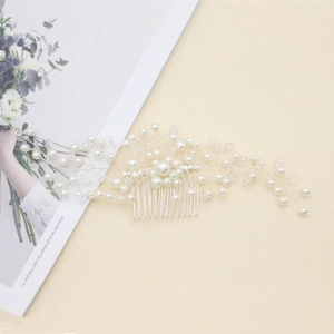 Detail of silver bridal hair comb with ivory pearls and crystals in a branch design