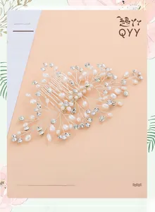 Close-up of bridal hair comb with silver wire, white pearls and clear crystals