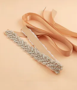 Détail d'une ceinture de mariée en cristal avec ruban de soie champagne pour robe de mariée