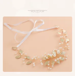 Détail du bandeau de mariée en feuilles dorées avec perles blanches et ruban de soie