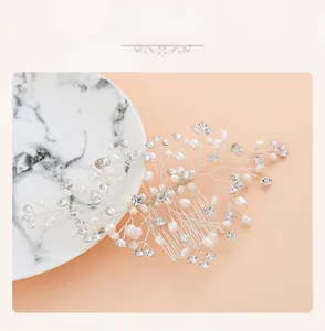 Macro detail of bridal hair comb with pearls and rhinestones on a marble surface