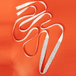 Ceinture de mariée élégante avec strass en cristal sur ruban de satin blanc sur fond orange