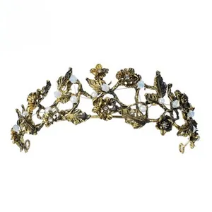 Close-up of vintage golden leaf crown with pearls and rhinestones on white background