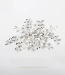 Détail d'un peigne de mariée avec fleurs argentées, perles et strass bleus brillants