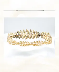 Macro detail of handmade gold alloy leaf crown featuring intricate feathery leaf patterns