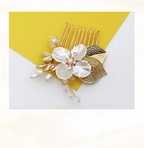 Détail d'un peigne à cheveux feuille d'or fait main avec fleurs blanches, perles et cristaux