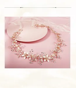 Détail de bandeau mariée or rose avec strass, fleurs émaillées et perles rondes