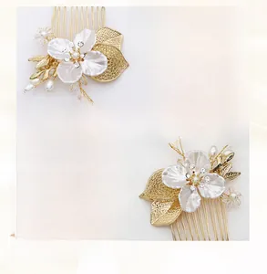 Détails macro d'un peigne de mariée avec feuilles dorées, perles et fil artisanal