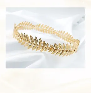 Detailed macro view of handmade copper wire weaving on a golden laurel leaf bridal crown