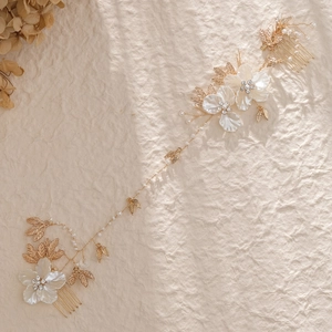 Handgefertigte Braut-Haarranke mit Muschelblüten, goldenen Blättern und Perlen auf Papier