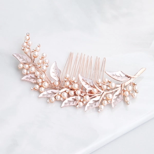 Elegant rose gold bridal hair comb with pearls and rhinestones on marble background