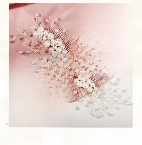 Macro detail of handmade bridal hair comb with white pearls and clear crystals on gold wire