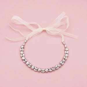 Serre-tête de mariée vintage en métal argenté et strass clairs sur fond de texture rose