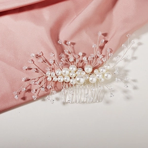 Elegant bridal hair comb with pearls and crystals on soft pink satin background