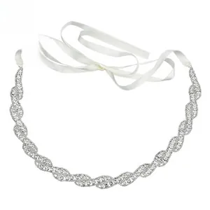 Detail showing wave-pattern rhinestones on a bridal belt with white satin ribbons