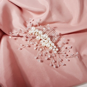 Handmade bridal hair comb with pearls and crystals on elegant pink silk background