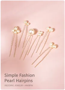 Close-up of elegant bridal pearl hair pins with gold wave design on pink background