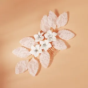 Detail von Braut-Haarkamm mit weißen Spitzenblättern und funkelnden Strassblumen