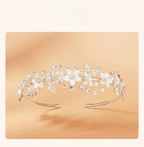 Detailed close-up of bridal headband with white floral elements and sparkling pearls